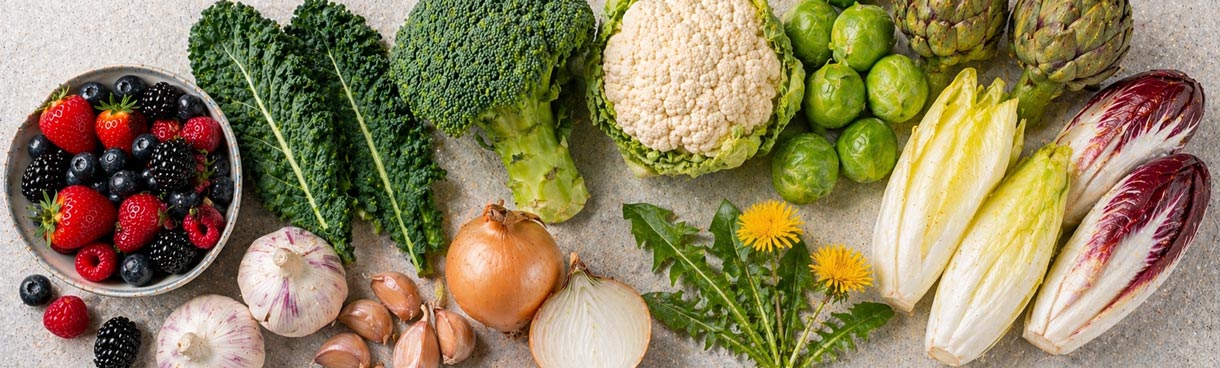 Flatlay mit Brokkoli, Blumenkohl, Knoblauch, Zitrusfrüchten und Bitterkräutern — Lebensmittel zur Unterstützung der körpereigenen Entgiftung